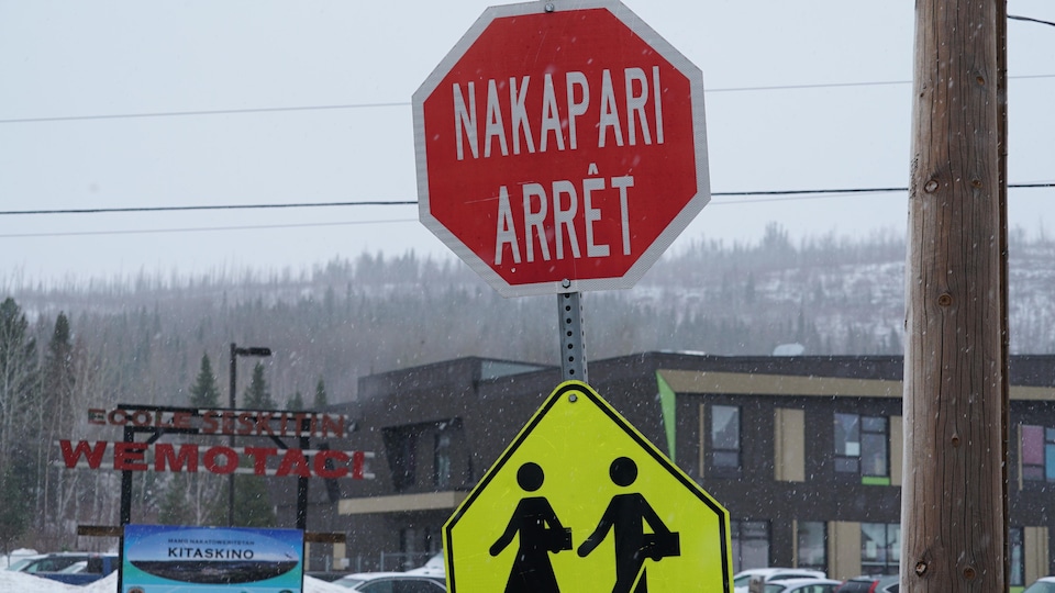 Un panneau d'arrêt en français et en atikamekw devant l'école.