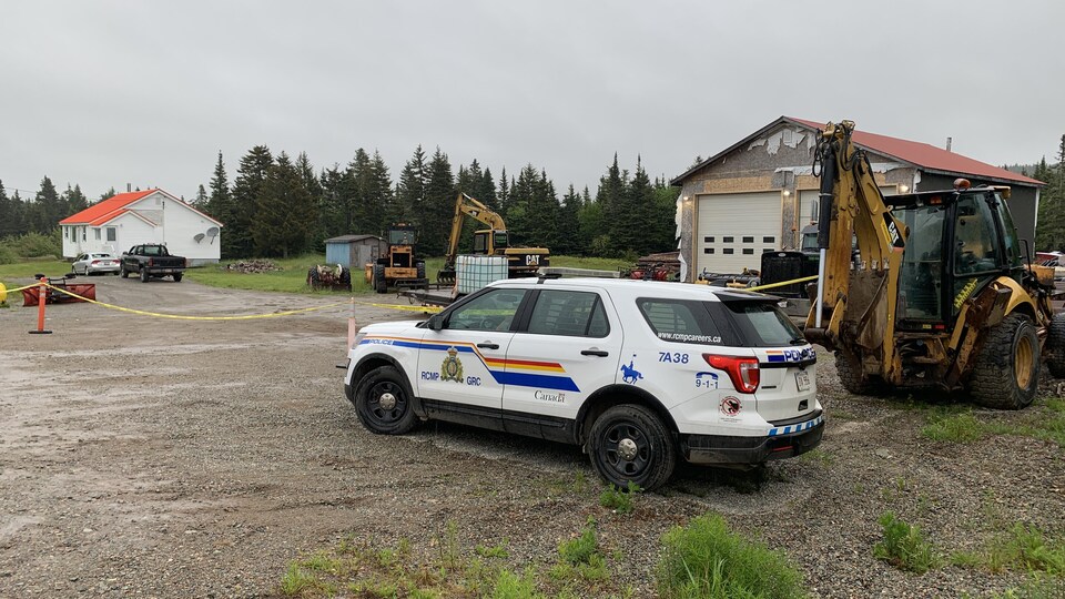 La voiture de la police se trouve devant l'entrée de la maison.