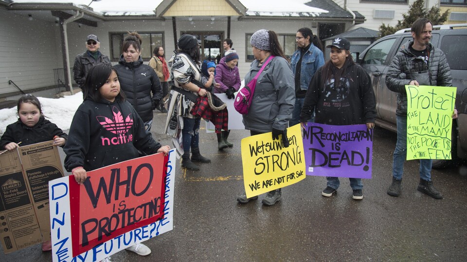 Des manifestants qui appuient les chefs héréditaires de Wet'suwet'en portent des pancartes.