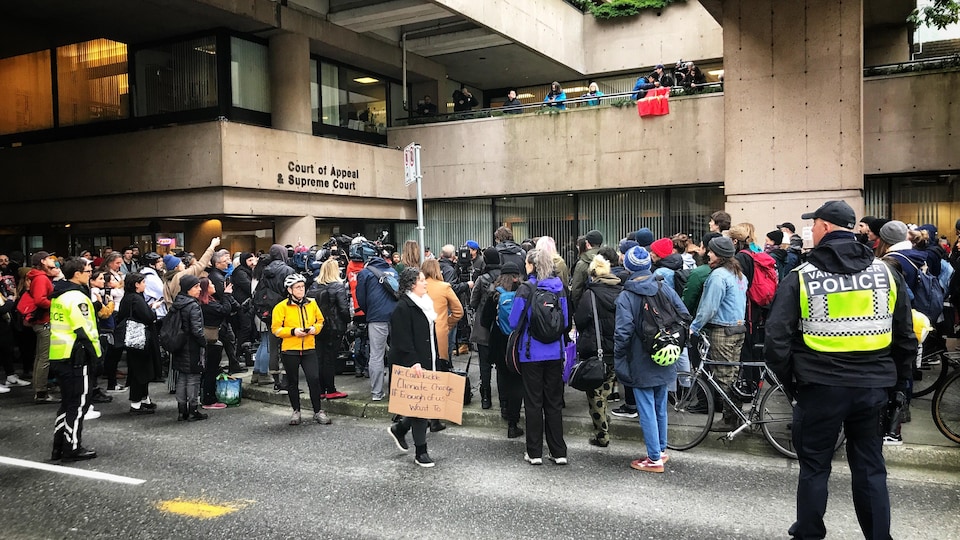 Des policiers surveillent des manifestants se sont rassemblés mercredi devant la Cour suprême de la Colombie-Britannique à Vancouver.