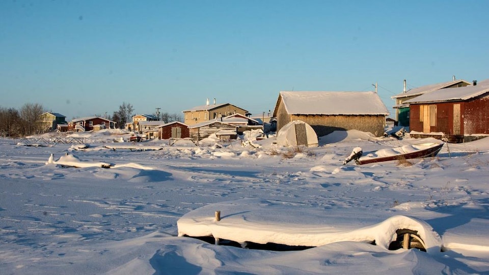 La marina de Whatì avec des quais et des bateaux recouverts de neige.