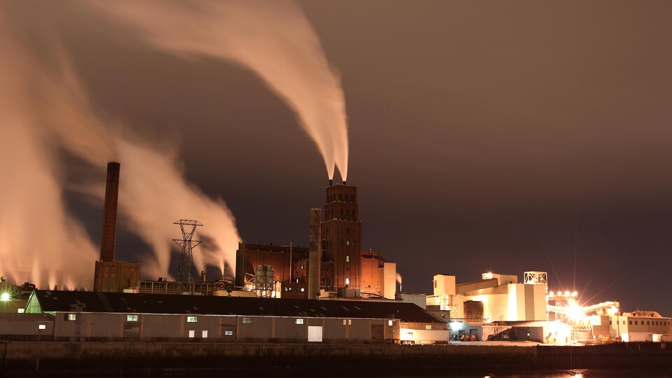 L'usine Papiers White Birch dans le port de Québec par un soir de novembre. L'exposition longue permet de voir les panaches de fumée dessiner de longs traits ondulés.