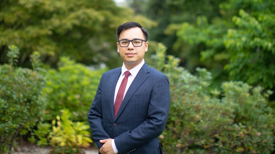 Wilson Miao pose en costume au milieu d'arbres.