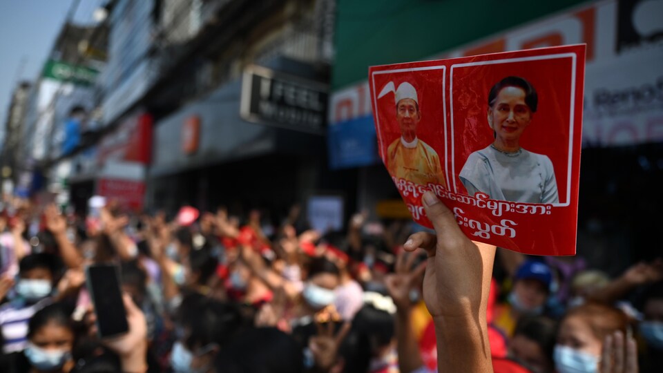 Un manifestant tient une photo de Win Myint et d'Aung San Suu Kyi.