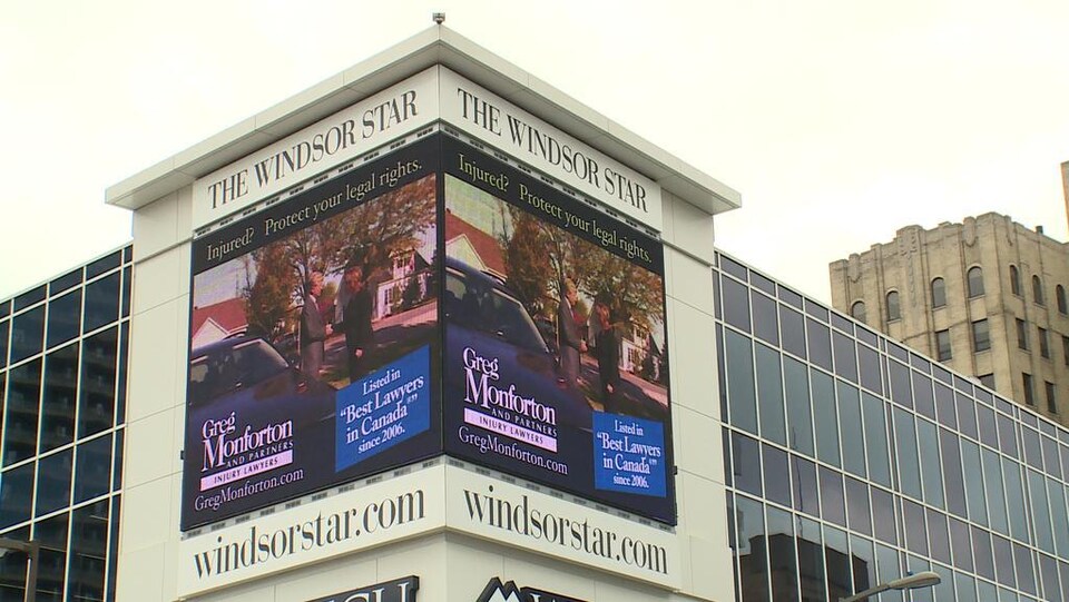 Des écrans publicitaires sont placés sur la façade de l'immeuble, sous l'enseigne The Windsor Star. 