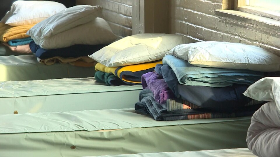 Des couvertures, des oreillers et des serviettes sur des lits dans un refuge.