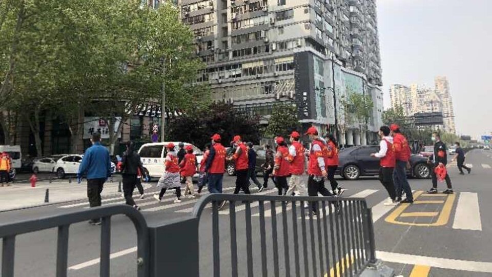Des travailleurs bénévoles contrôlent la température de la population dans les rues.