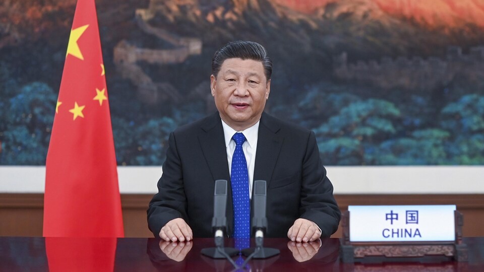 Le président chinois Xi Jinping assis derrière un bureau.