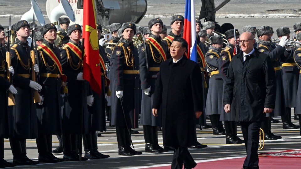 Xi Jinping et Dmitri Chernichenko marchent devant des soldats russes.