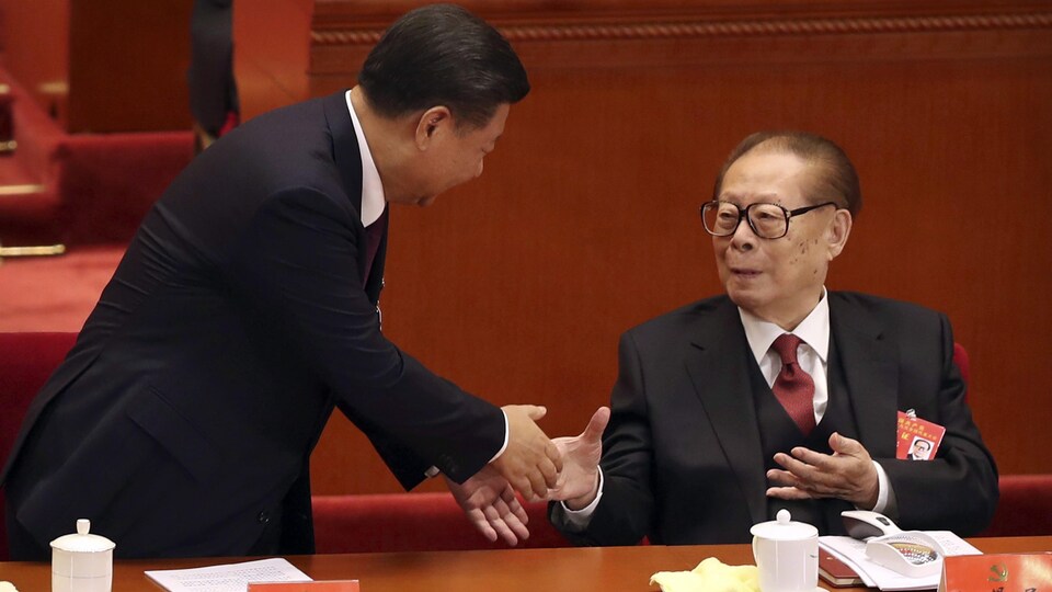 Le président Xi serre la main de Jiang Zemin.