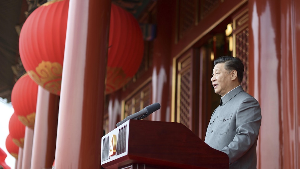 Xi Jinping derrière un micro regardant droit devant