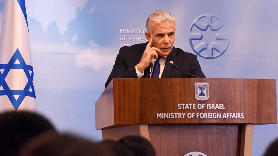 Yaïr Lapid s'adresse à la presse derrière un lutrin.
