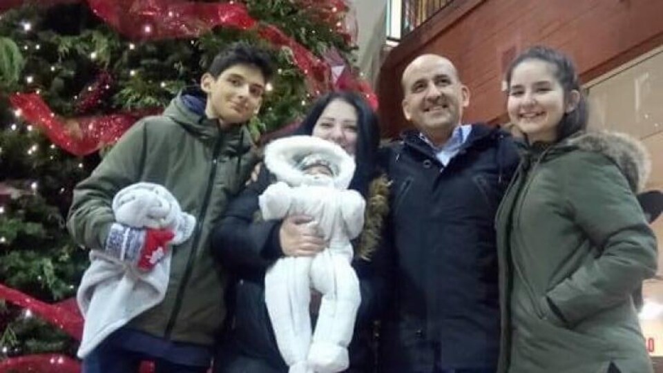 Une famille de cinq devant un arbre de Noël.