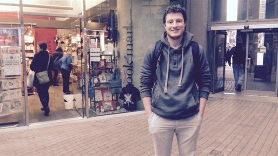 Yann Lacoste, nouveau président du Conseil jeunesse francophone de la Colombie-Britannique, devant une boutique de la bibliothèque municipale de Vancouver