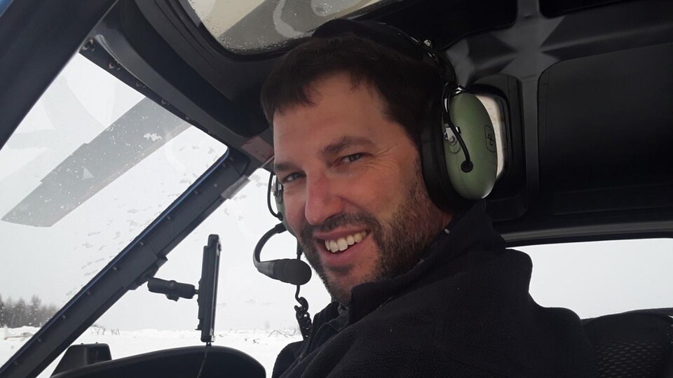 Yannick Bilodeau poses for the camera aboard a helicopter.