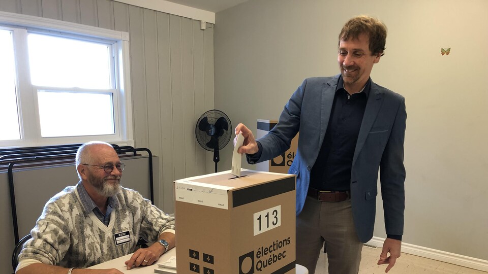 Yannick Gagnon dépose son bulletin de vote dans une boîte de scrutin d'Élections Québec