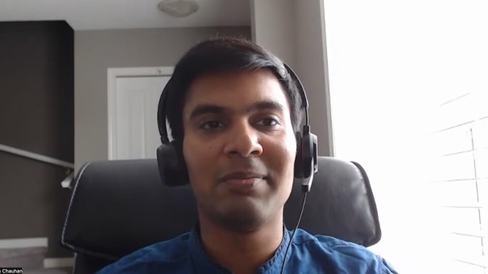 Yash Chauhan, portant un casque d'écoute, assis à son bureau, en visioconférence.
