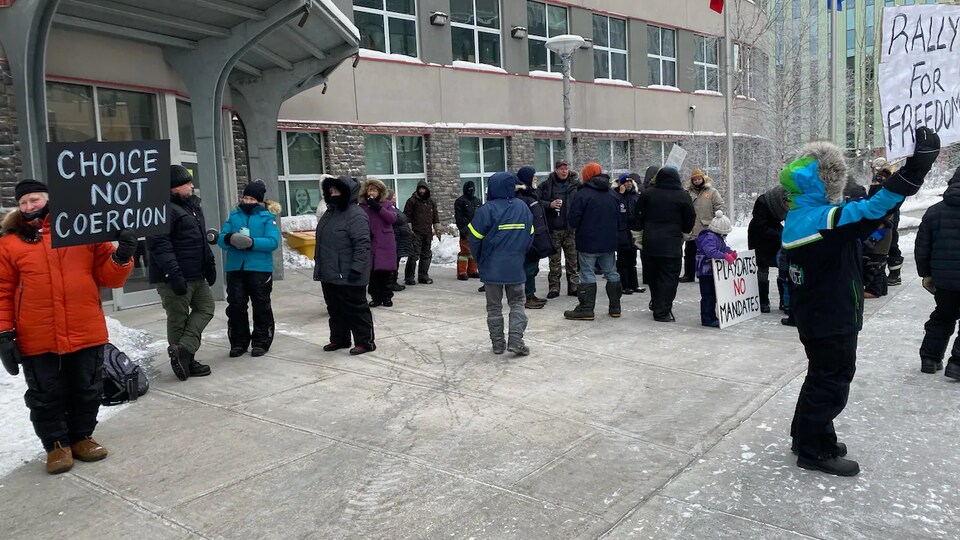 Une quarantaine de manifestants munis de pancartes sont devant un immeuble de Yellowknife pour dénoncer les mesures sanitaires.