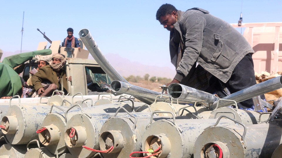 Des hommes armés sur un camion transportant des armes.