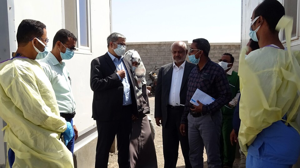 Des personnent s'entretiennent à l'extérieur.