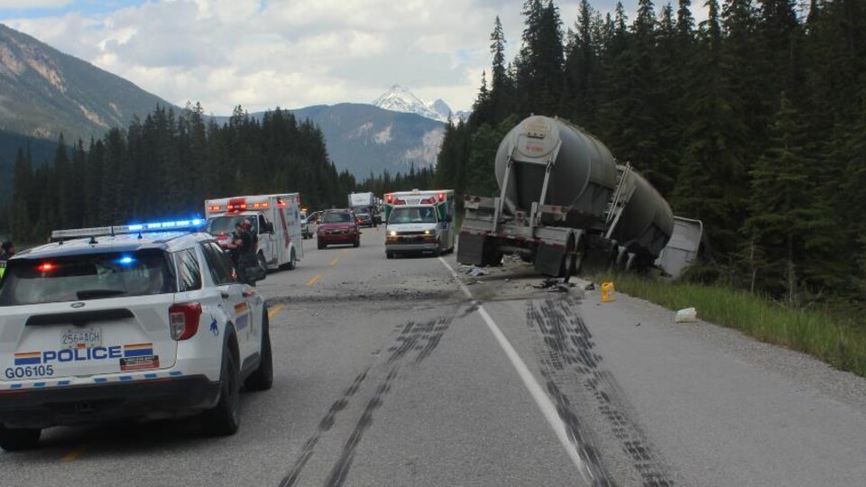 Un camion sorti de route entouré de véhicules d'urgence.