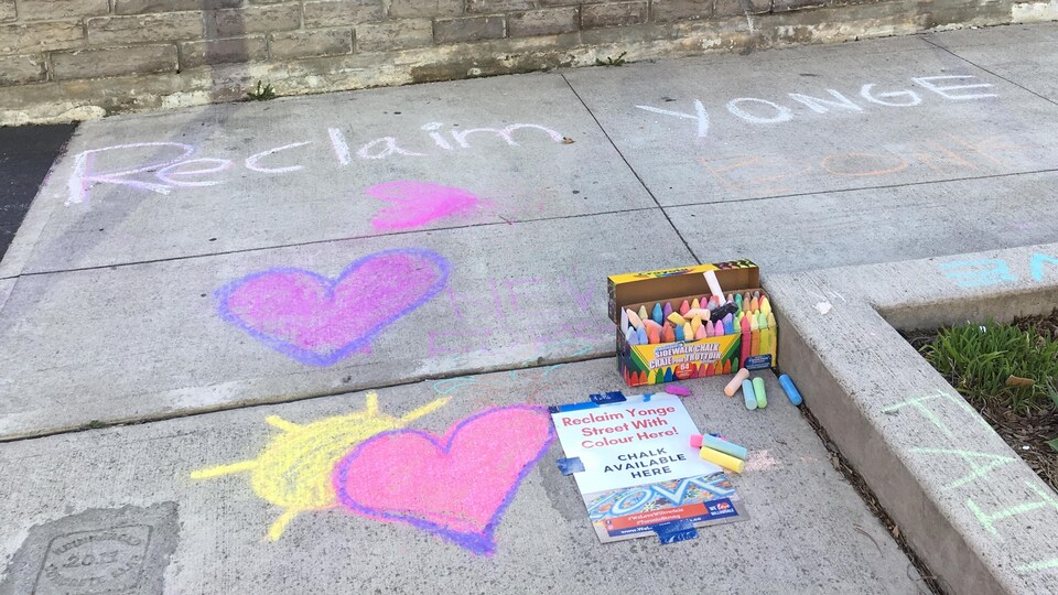 Photo de coeurs dessinés à la craie sur le trottoir.