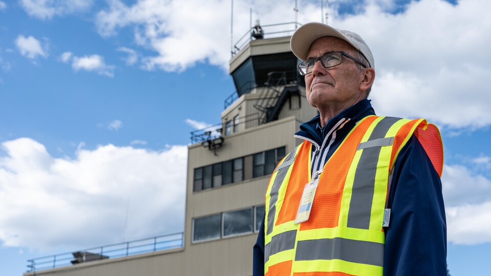 Dave White pose devant la tour de contrôle de l'aéroport de Whitehorse.
