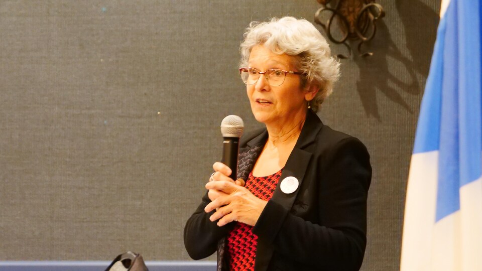 Jeanne Beaudoin parle dans un micro.