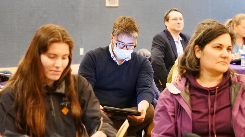 Un participant portant le masque regarde une tablette.