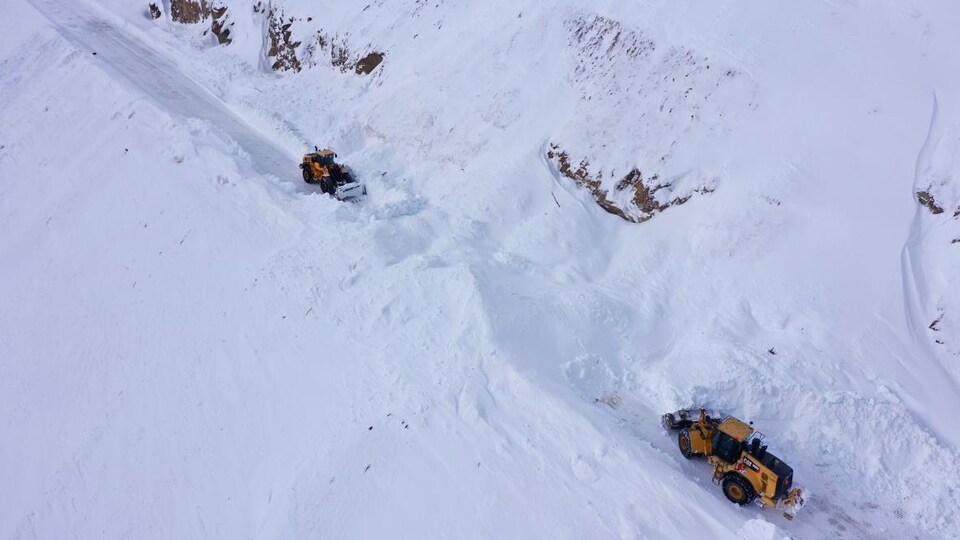 Vue des airs d'une section de la route où de la machinerie dégage de la neige.