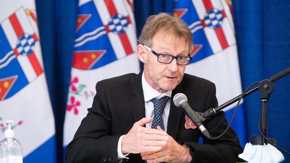 Brendan Hanley parle dans un micro lors d'une conférence de presse.
