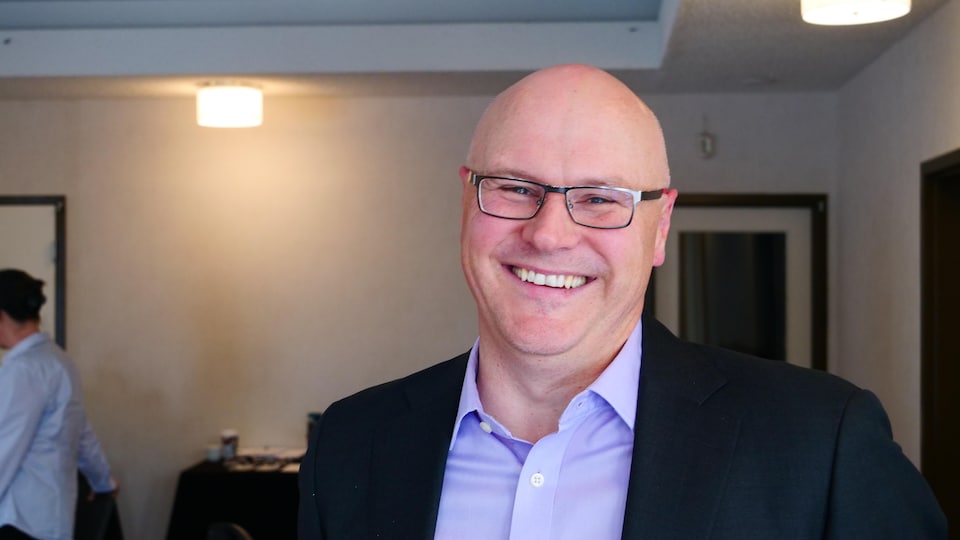 Andrew Hall sourit à la caméra.