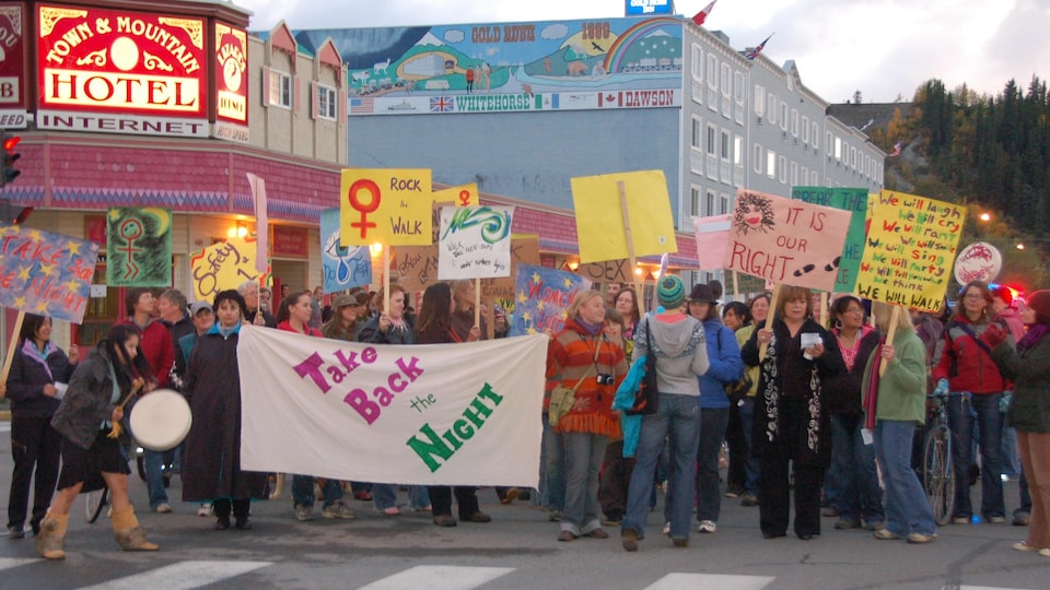 Des femmes avec des banderoles sur la rue.