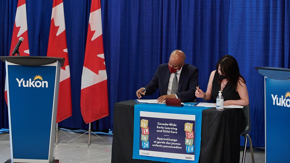 Jeanie McLean et Ahmed Hussen signent l'entente en conférence de presse.