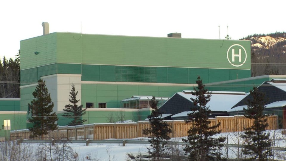 Un hôpital vu l'hiver. L'édifice est de couleur verte.