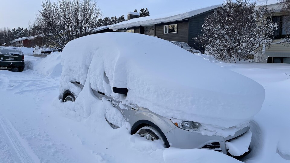 Une voiture est enfouie sous une épaisse couche de neige à Whitehorse.
