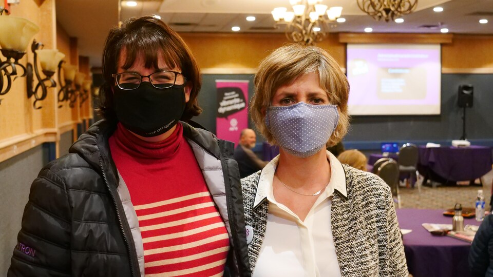 Deux femmes sourient derrière leurs masques.