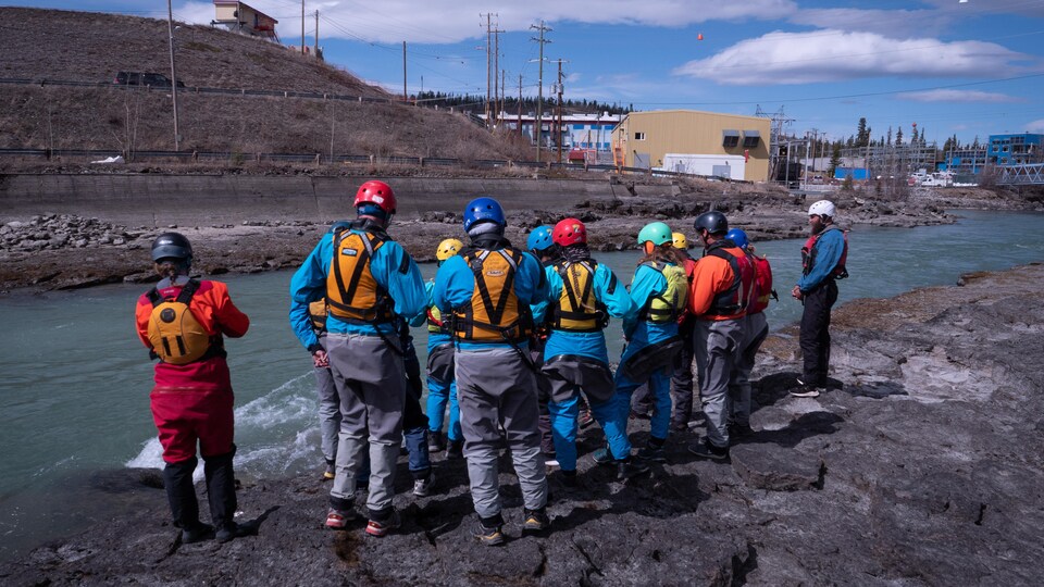 Une douzaine de personnes regardent le fleuve Yukon, le 10 mai 2023. 