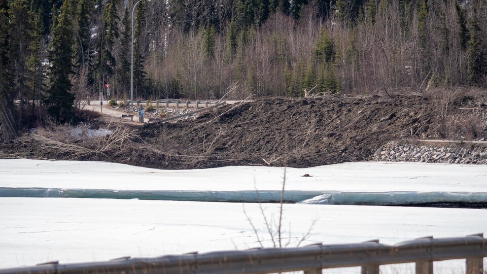 Les débris d'un glissement de terrain recouvrent une route, un sentier et le bord du fleuve Yukon.