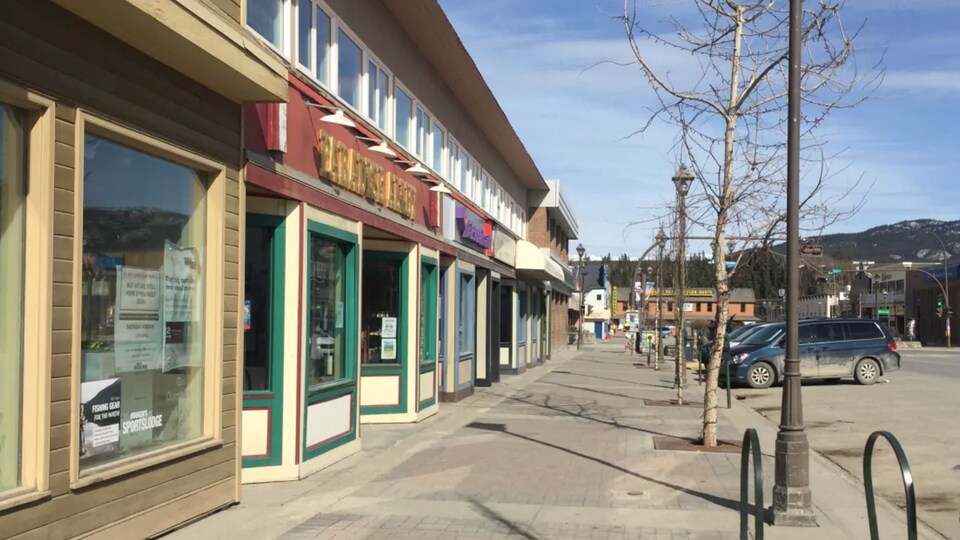 Trottoir désert devant une série de boutiques.
