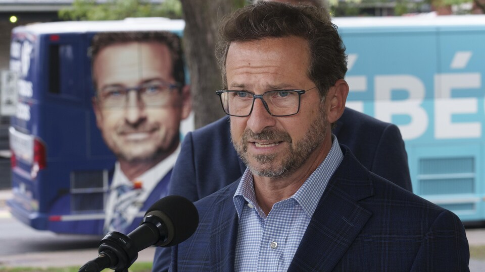 Yves-François Blanchet s'adresse aux médias devant son autobus de campagne.