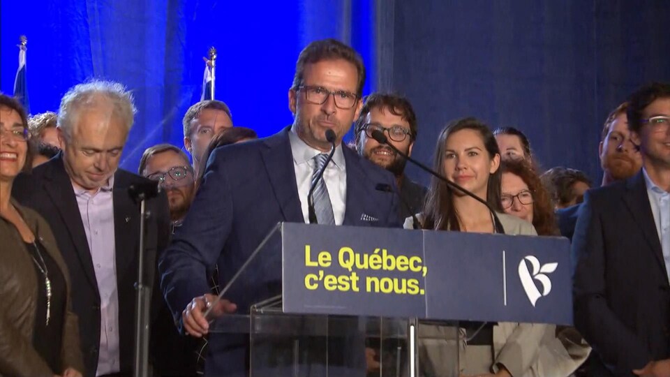 Yves-François Blanchet s'adresse à ses militants. Derrière lui, se trouvent tous les candidats bloquistes.