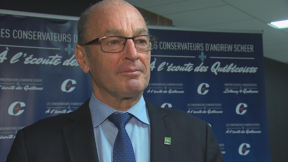 Le maire Yves Lévesque devant les panneaux de la tournée québécoise de consultation d'Andrew Scheer