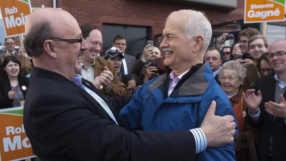Le député d'Acadie-Bathurst serre dans ses bras l'ancien chef néo-démocrate Jack Layton, devant des partisans. 