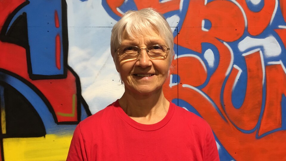 Yvonne Gauvin devant un mur de graffitis