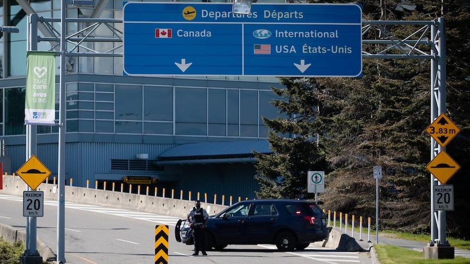 Un policier bloque la route à l'aéroport international de Vancouver.