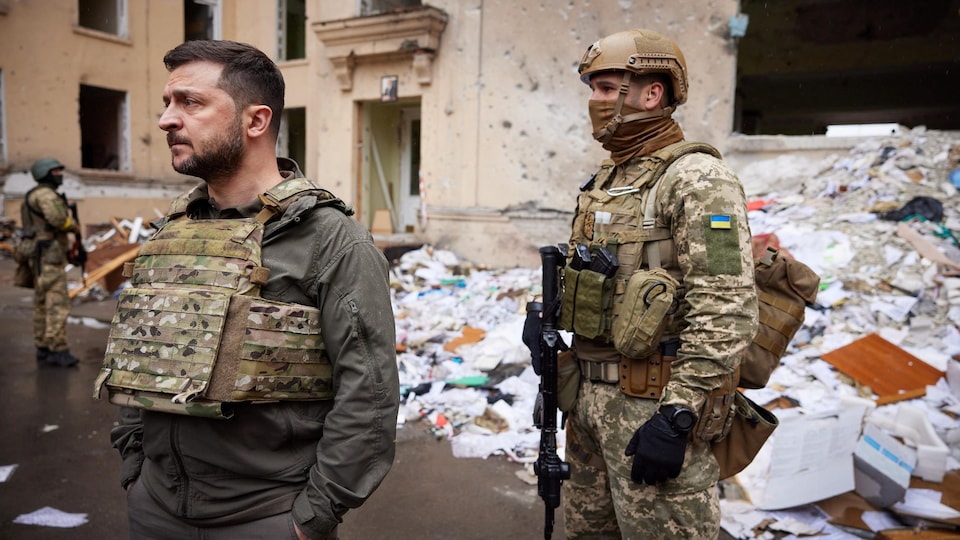 Wearing a bulletproof vest and accompanied by an armed soldier, Volodymyr Zelensky examined the damage in Kharkiv