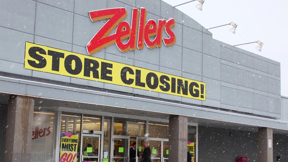 L'extérieur d'un magasin Zellers avec les affiches jaunes de ventes de liquidation.