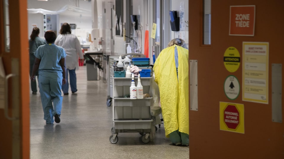 Des préposés dans un couloir d'un hôpital.