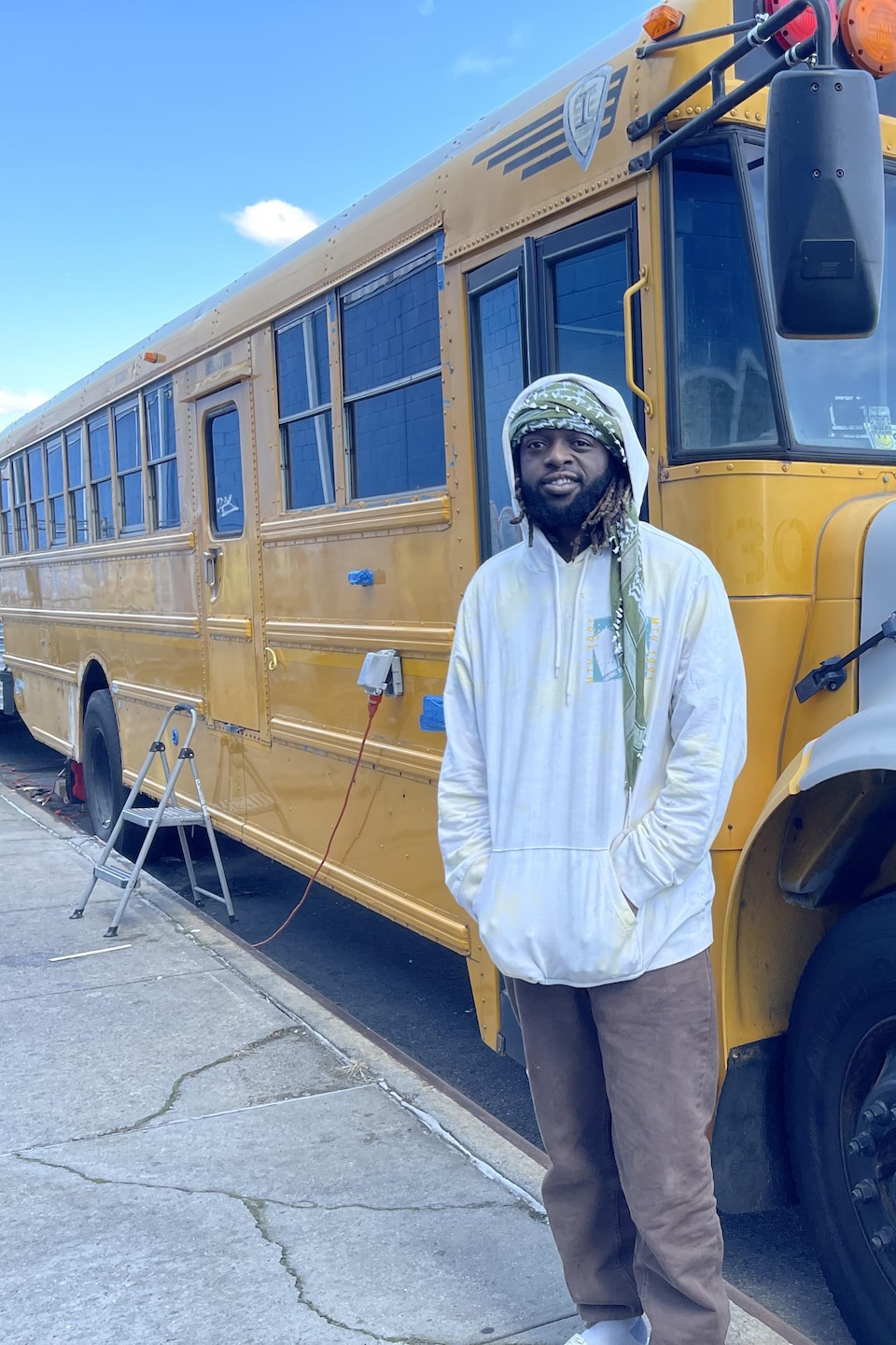 Abdul alias Legacy devant l'autobus scolaire qu'il a transformé en studio d'enregistrement